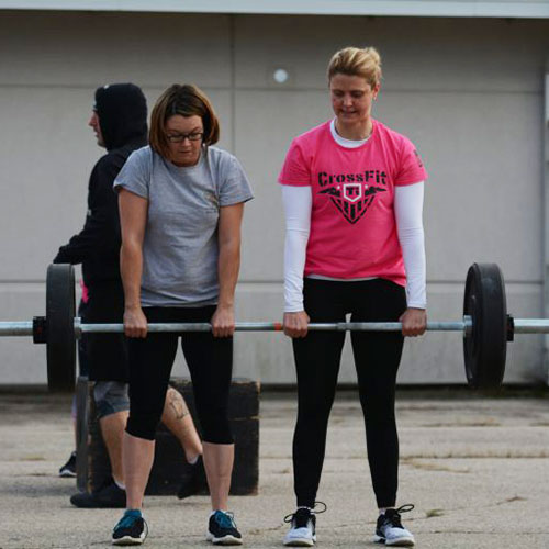 Two women lifting a barbell at Crossfit games