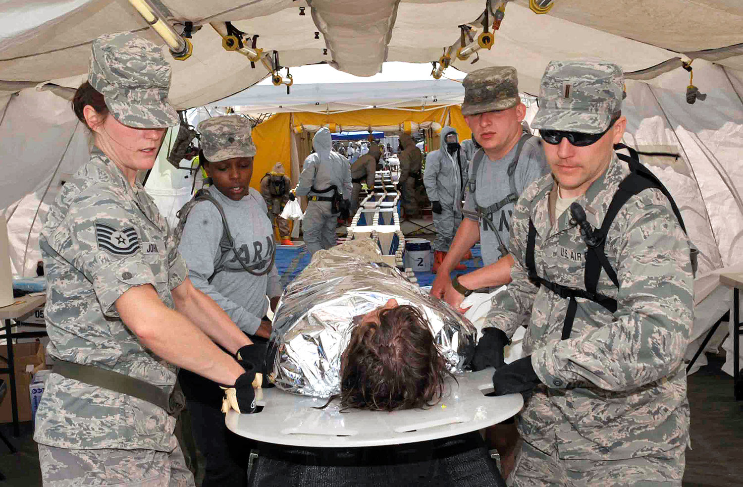 four 115th Fighter Wing members carry a man on a stretcher