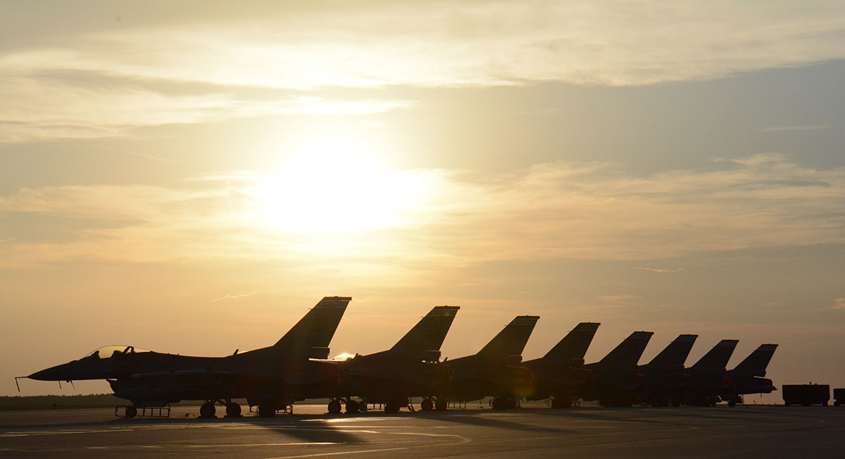 Row of F-35s jets with sun setting in the background